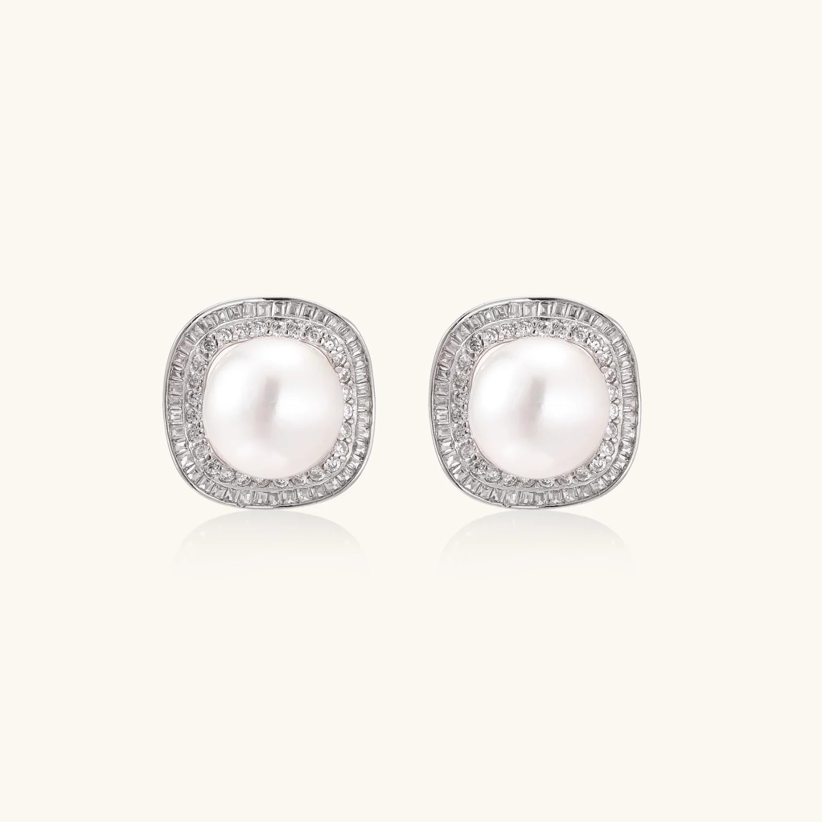 Cushion-shaped sterling silver stud earrings with freshwater pearls surrounded by geometric diamond halos