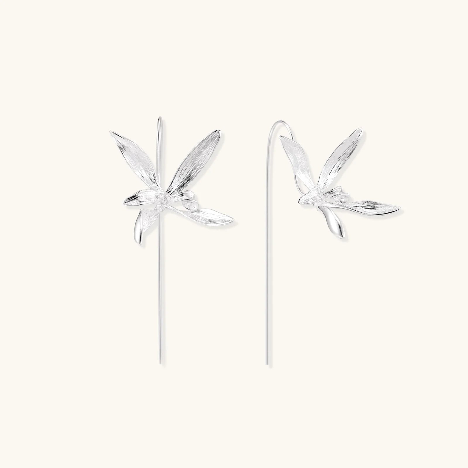 Delicate sterling silver dragonfly earrings with textured wings and curved threader hooks on white background