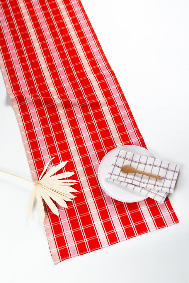Handwoven Camila plaid table runner in red, pink, and white cotton